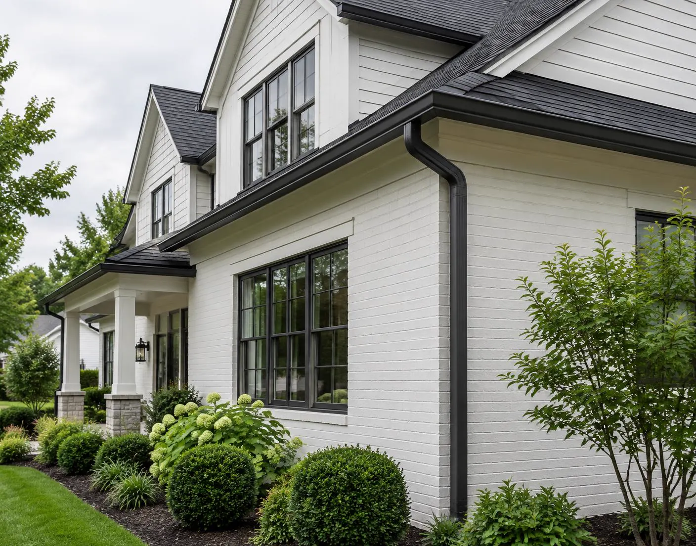 Dark seamless gutter and downspout on a light-sided home